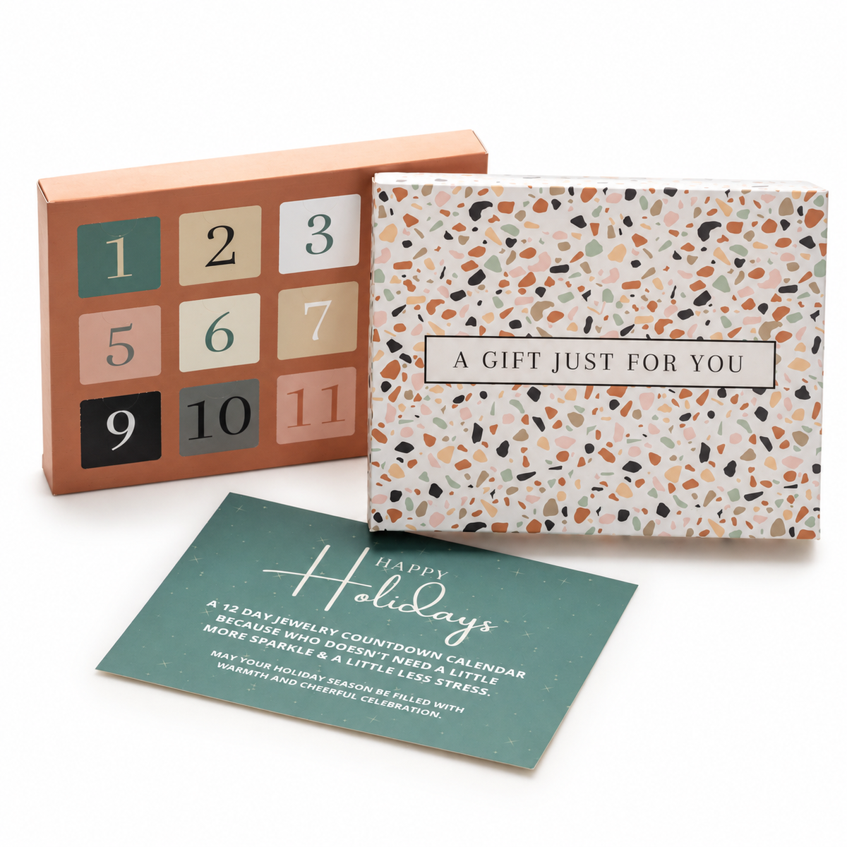 12 Days of Christmas jewellery calendar with terrazzo-patterned outer box and holiday card on a white background