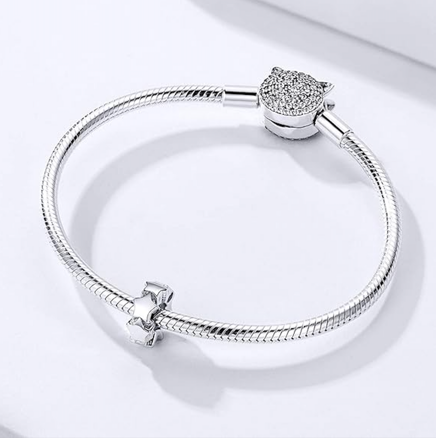 Sterling silver spacer charm formed by a ring of polished stars, smooth core, compatible with Pandora-style bracelets on snake chain bracelet as example.