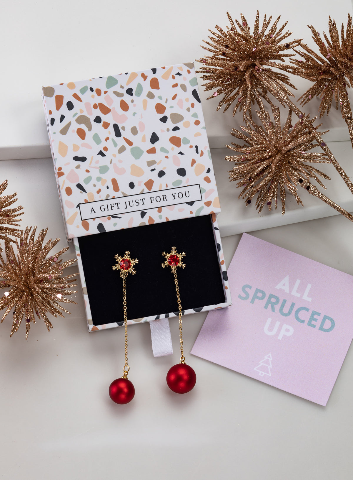 Gold-tone red snowflake chain earrings with red bead drops in an open gift box