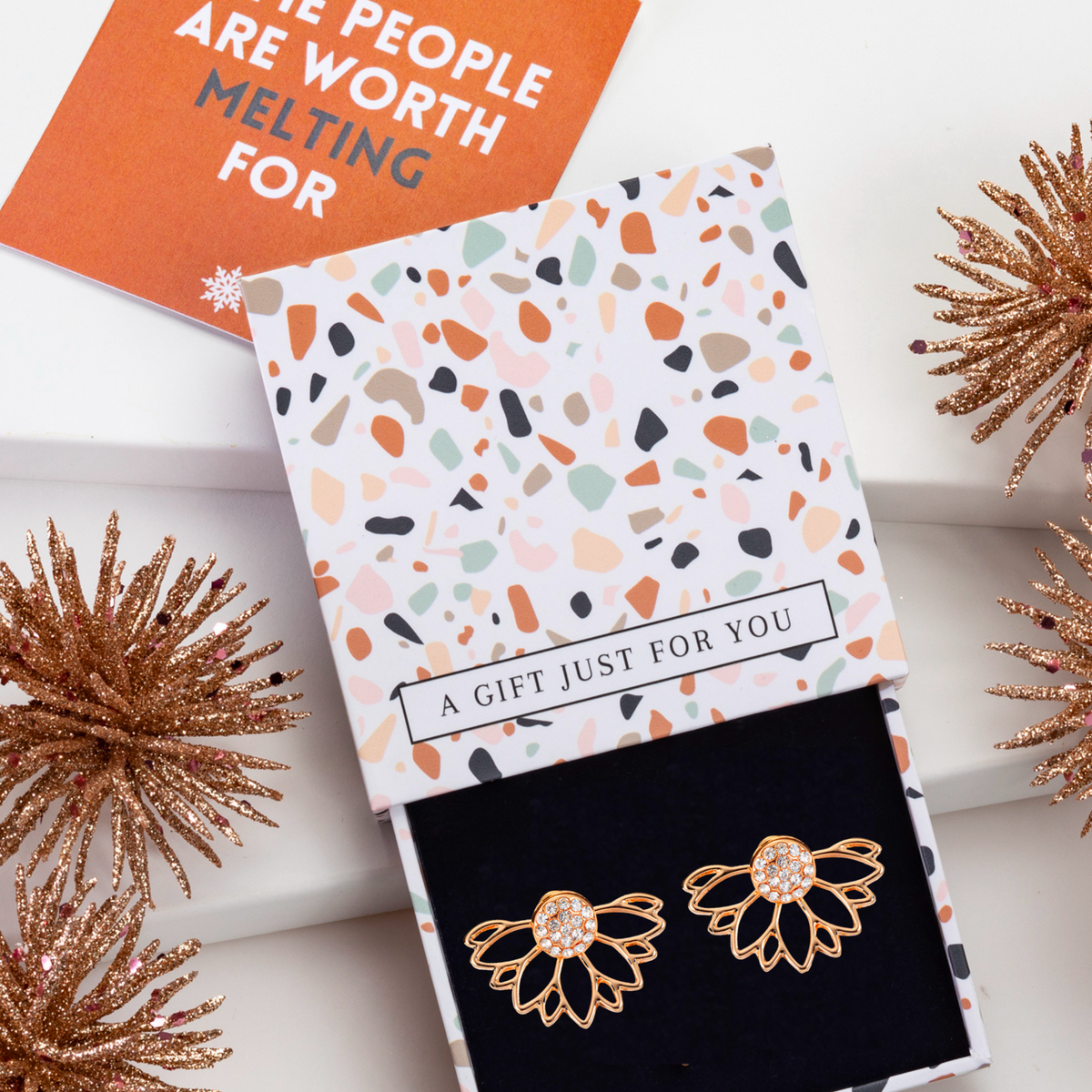 Gold-tone crystal lotus ear jackets in a patterned gift box