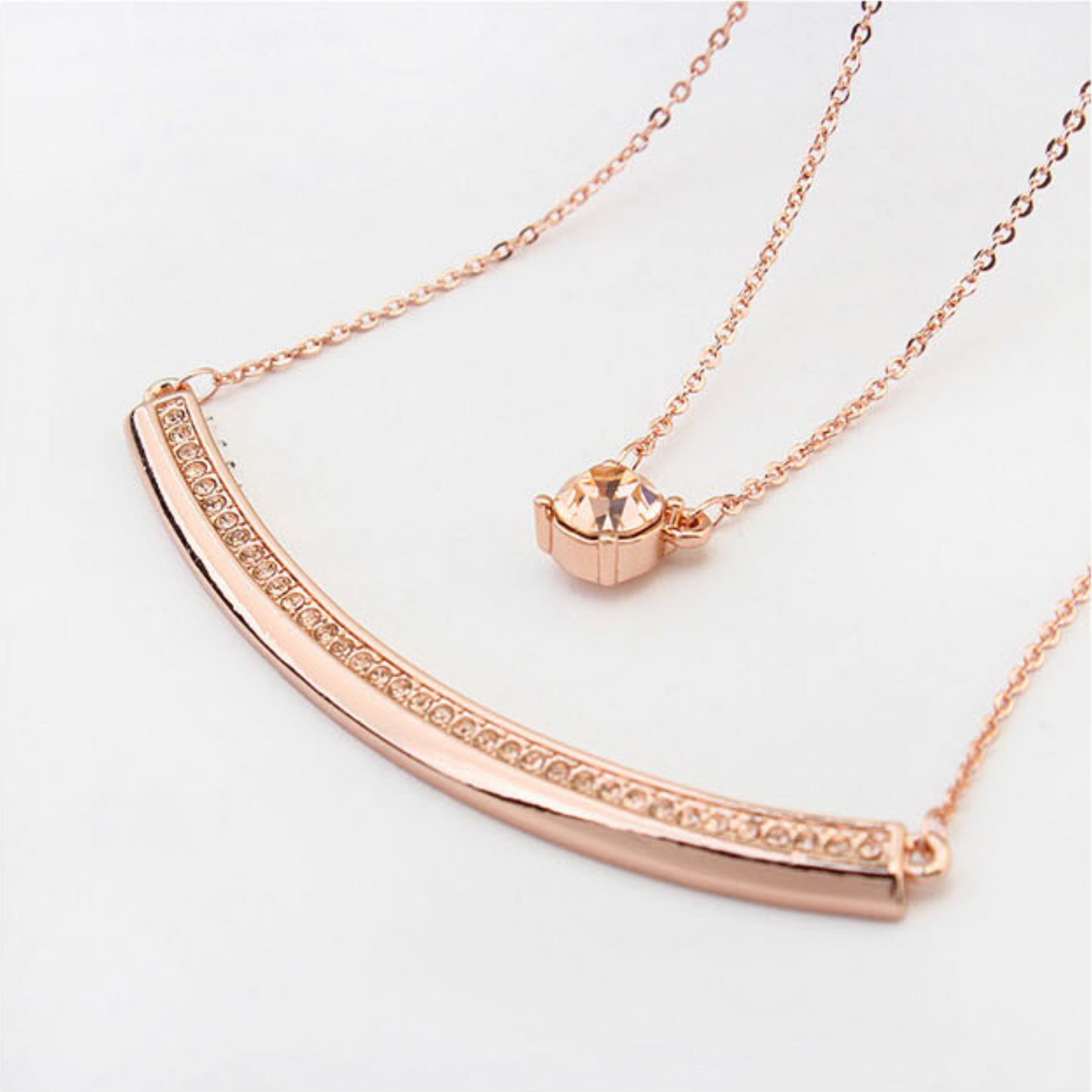Layered necklace with Swarovski crystals, rose gold and rhodium plated, featuring solitaire and curved bar design, adjustable 18-inch chain by callura