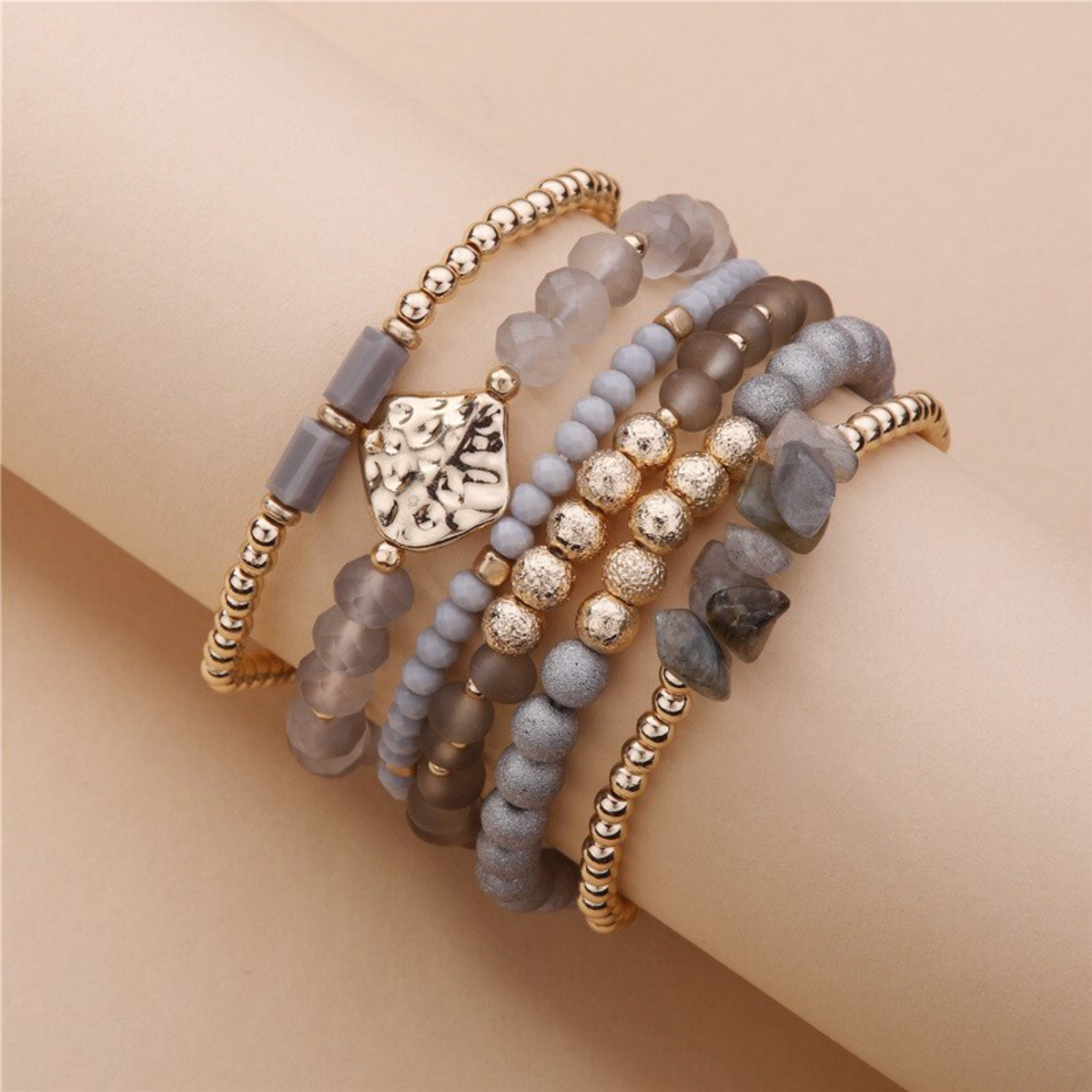 Gray bead and gold-tone bracelet set with crystal detailing, angled close-up