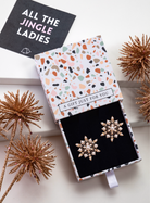 Faux pearl snowflake stud earrings in a patterned gift box with festive styling