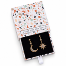 Gold-tone cubic zirconia moon and star drop earrings in a gift box on a white background