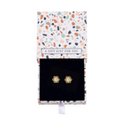Gold-tone cubic zirconia snowflake studs inside an open patterned gift box