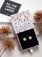 Gold-tone snowflake stud earrings in a patterned gift box with festive styling