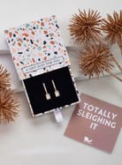 Cubic zirconia bar and baguette drop earrings in a patterned gift box with festive styling