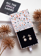 Gold-tone faux pearl and cubic zirconia leaf earrings in a patterned gift box with festive styling