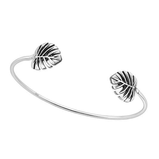 Sterling silver open cuff bracelet with two sculpted tropical leaf ends and subtle oxidised detail, minimalist adjustable women’s jewellery.