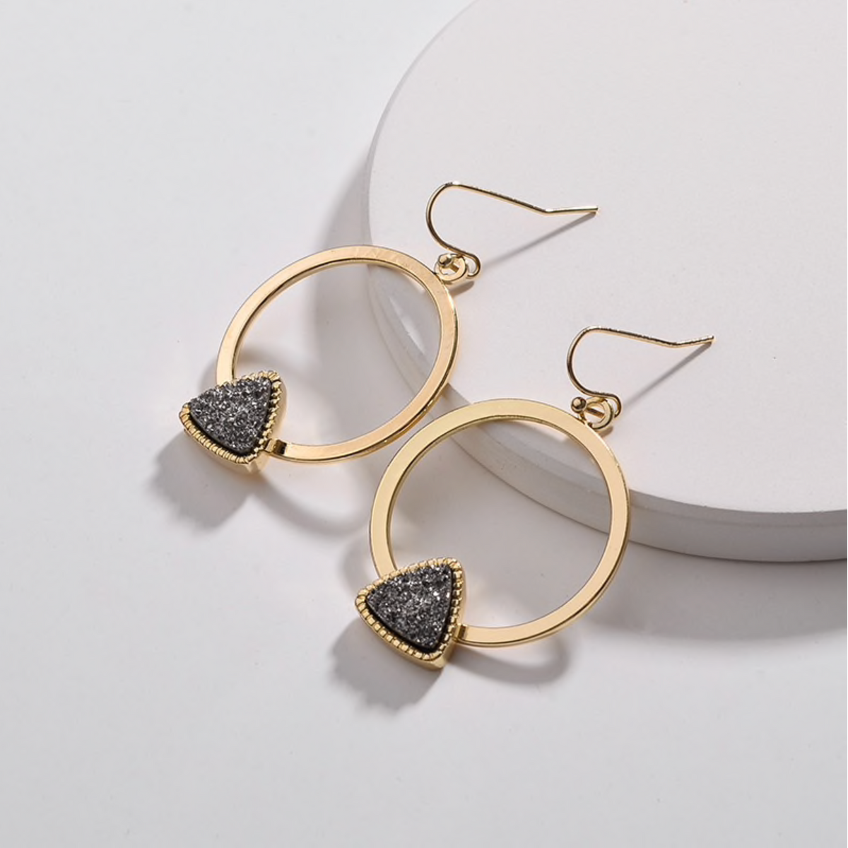 Gold-tone circular drop earrings with dark triangular druzy stones