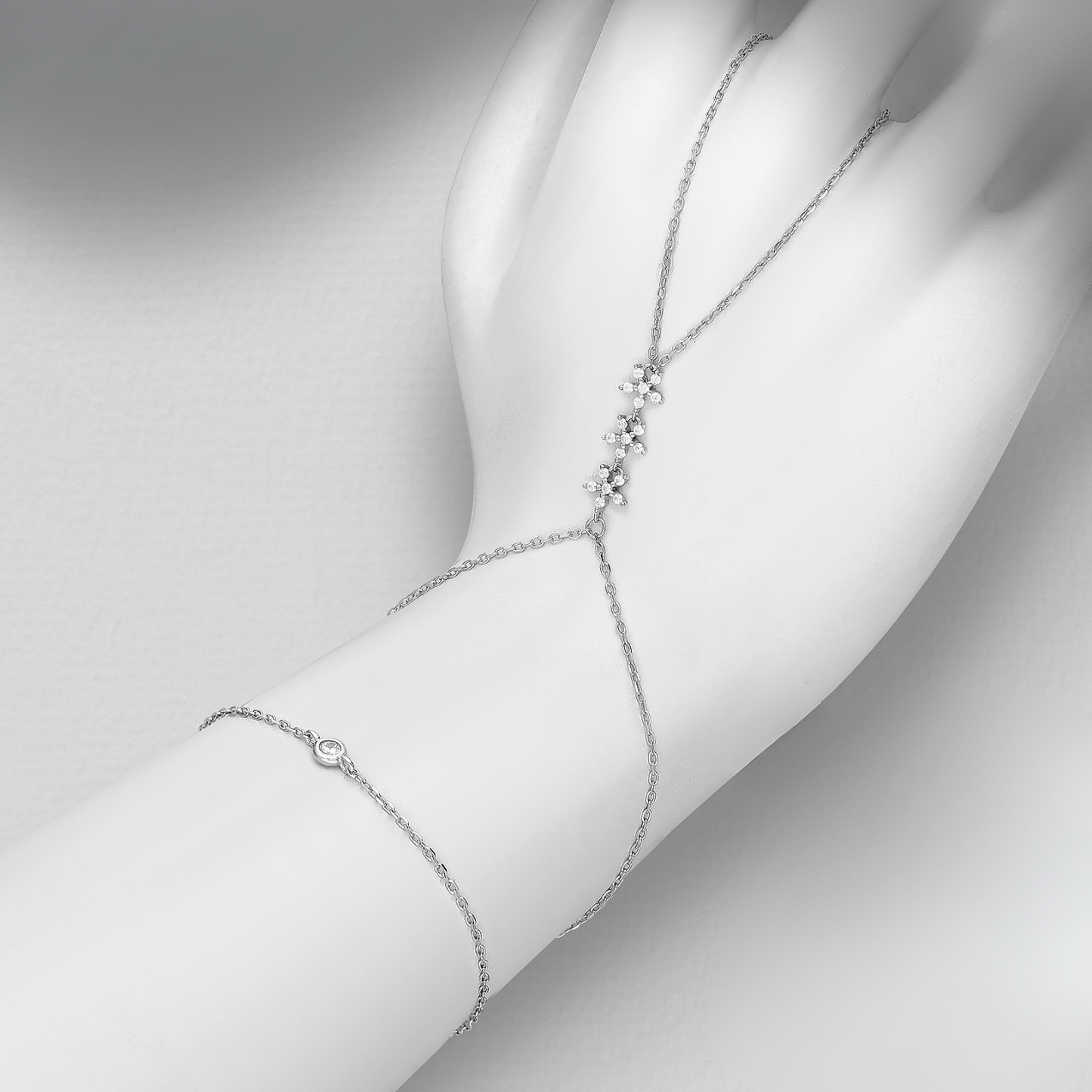 sterling silver hand chain bracelet (ring to wrist) with pavé CZ cluster and bezel-set stone on an adjustable rhodium-plated chain