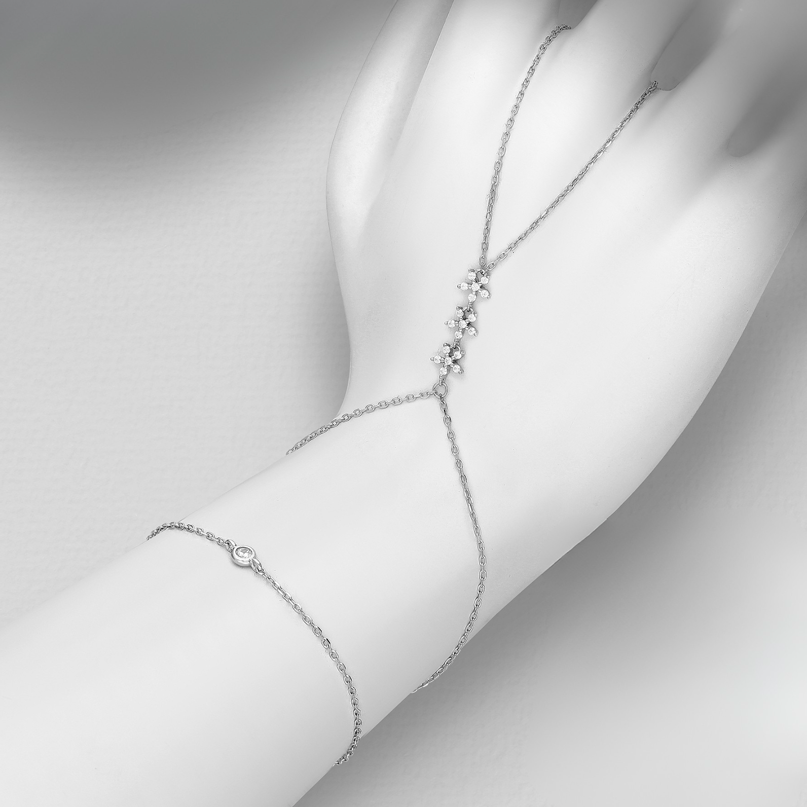 sterling silver hand chain bracelet (ring to wrist) with pavé CZ cluster and bezel-set stone on an adjustable rhodium-plated chain