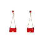 Red bag-shaped earrings with gold chains on a white background