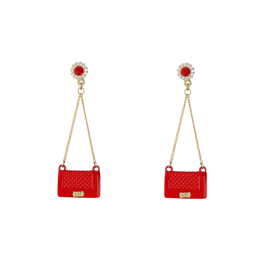 Red bag-shaped earrings with gold chains on a white background