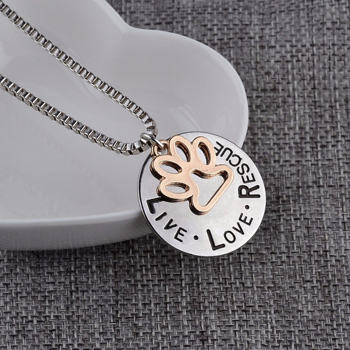 Two-tone round paw-print pendant engraved Live Love Rescue on a silver-tone chain