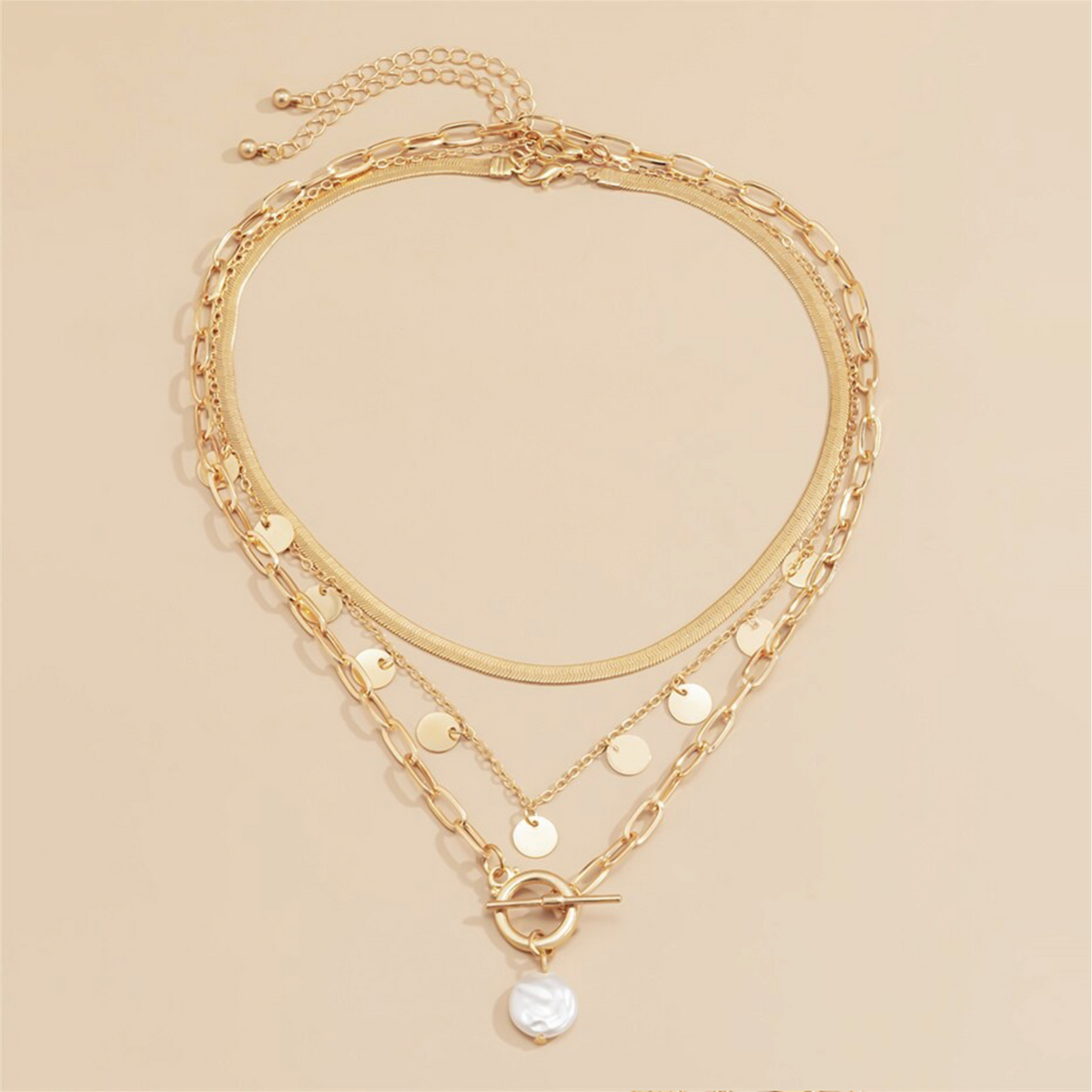 Gold-tone layered chain necklace with disc charms and a white faux pearl pendant