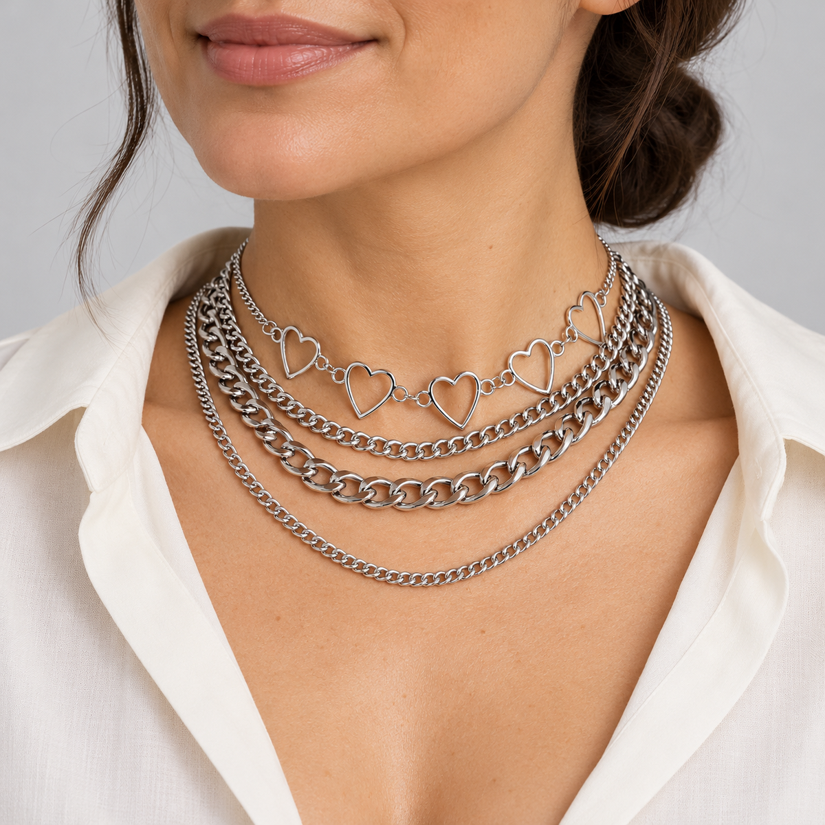 Model in a white blouse wearing a silvertone layered heart necklace