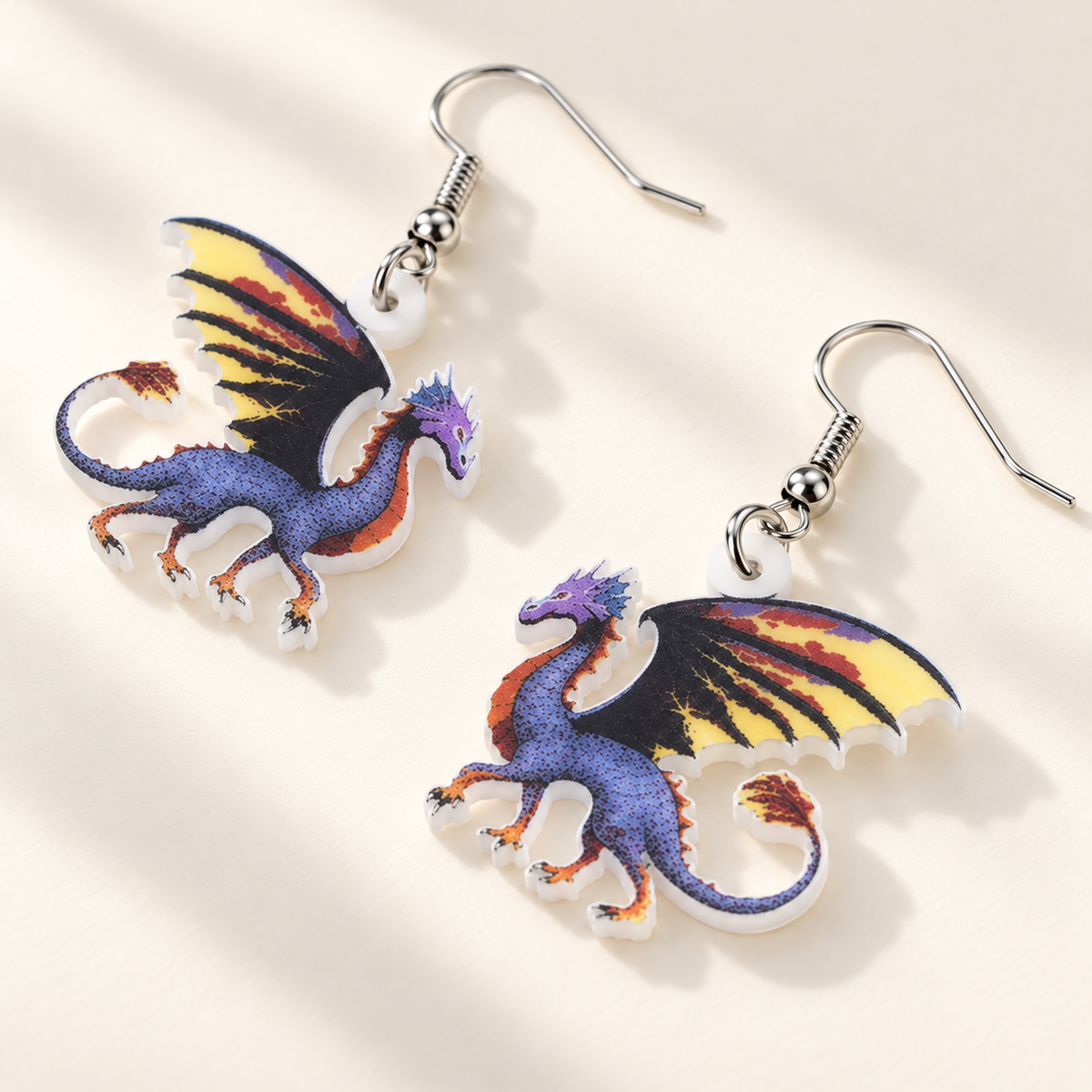 Purple dragon acrylic earrings arranged diagonally on an ivory surface