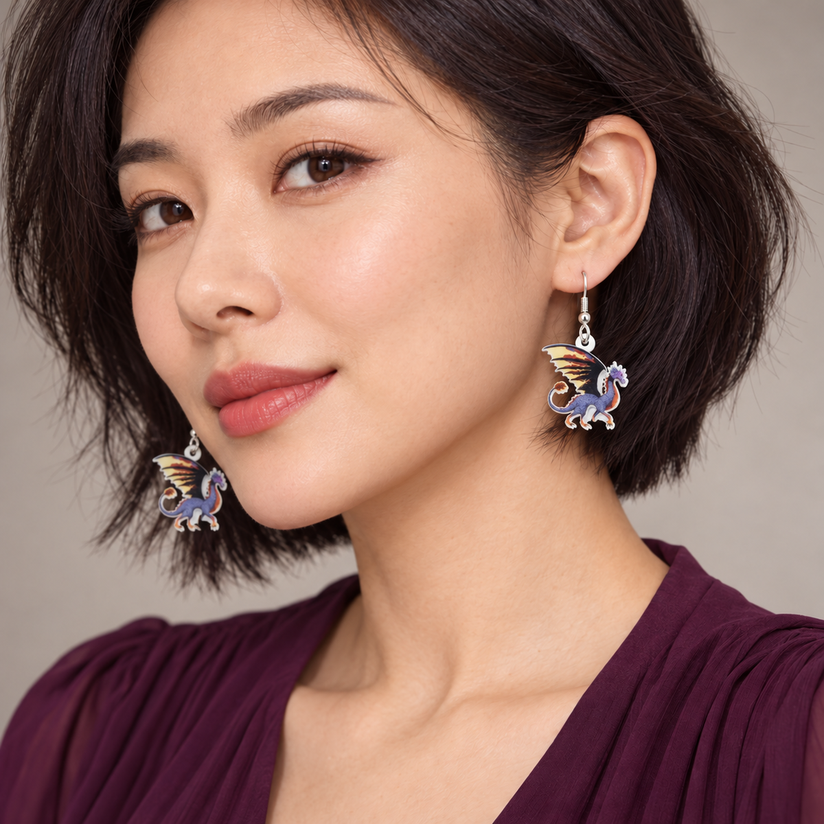 Purple dragon drop earrings worn by a short-haired model in a plum blouse