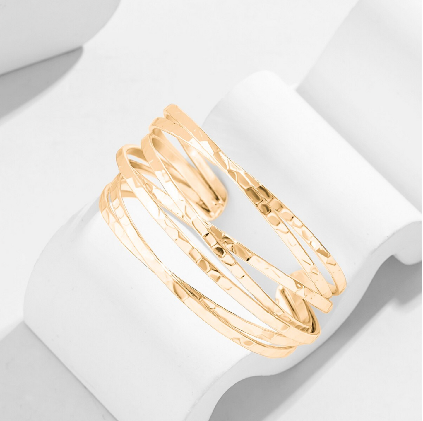 Gold bangles on a white surface