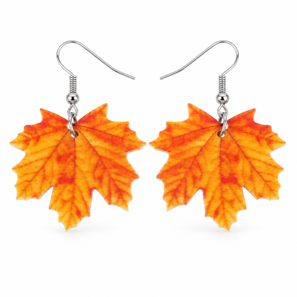 Orange maple leaf acrylic drop earrings with silver-tone hooks on white