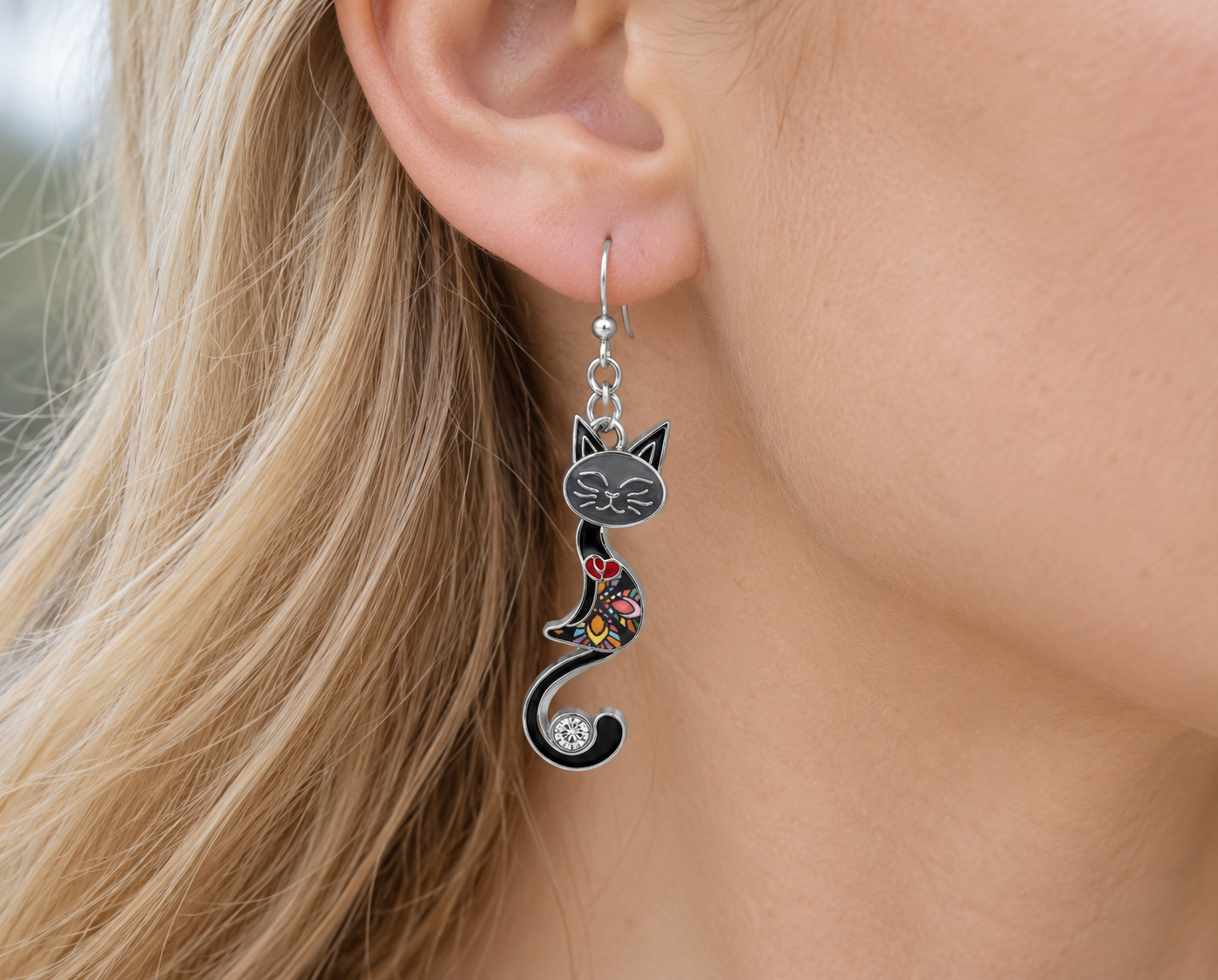 Black mosaic cat earring worn on an ear