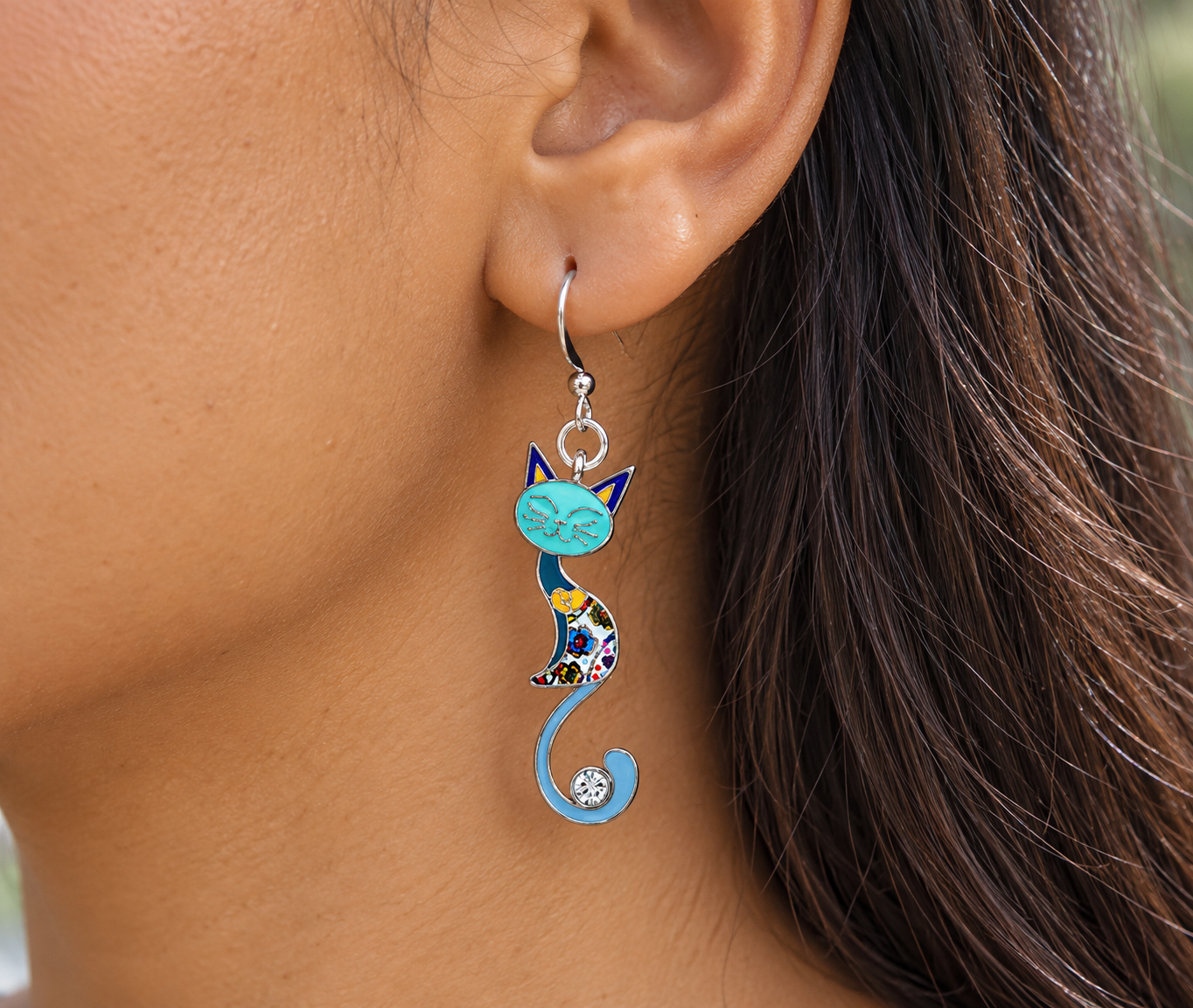 Blue mosaic cat earring worn on an ear