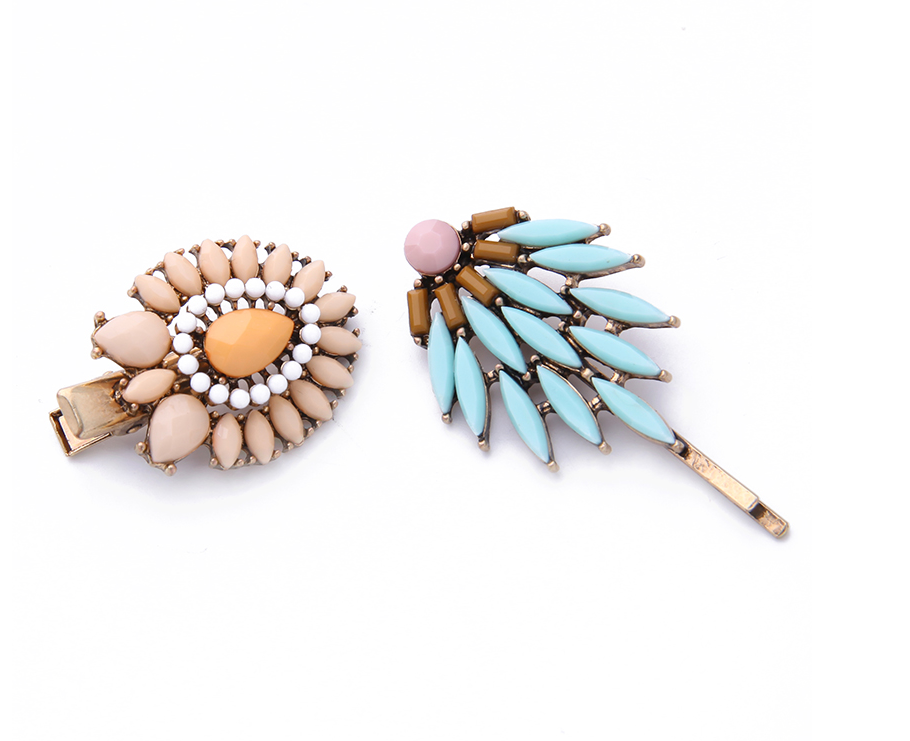 Two pastel hair pins with floral and turquoise-coloured geometric embellishments