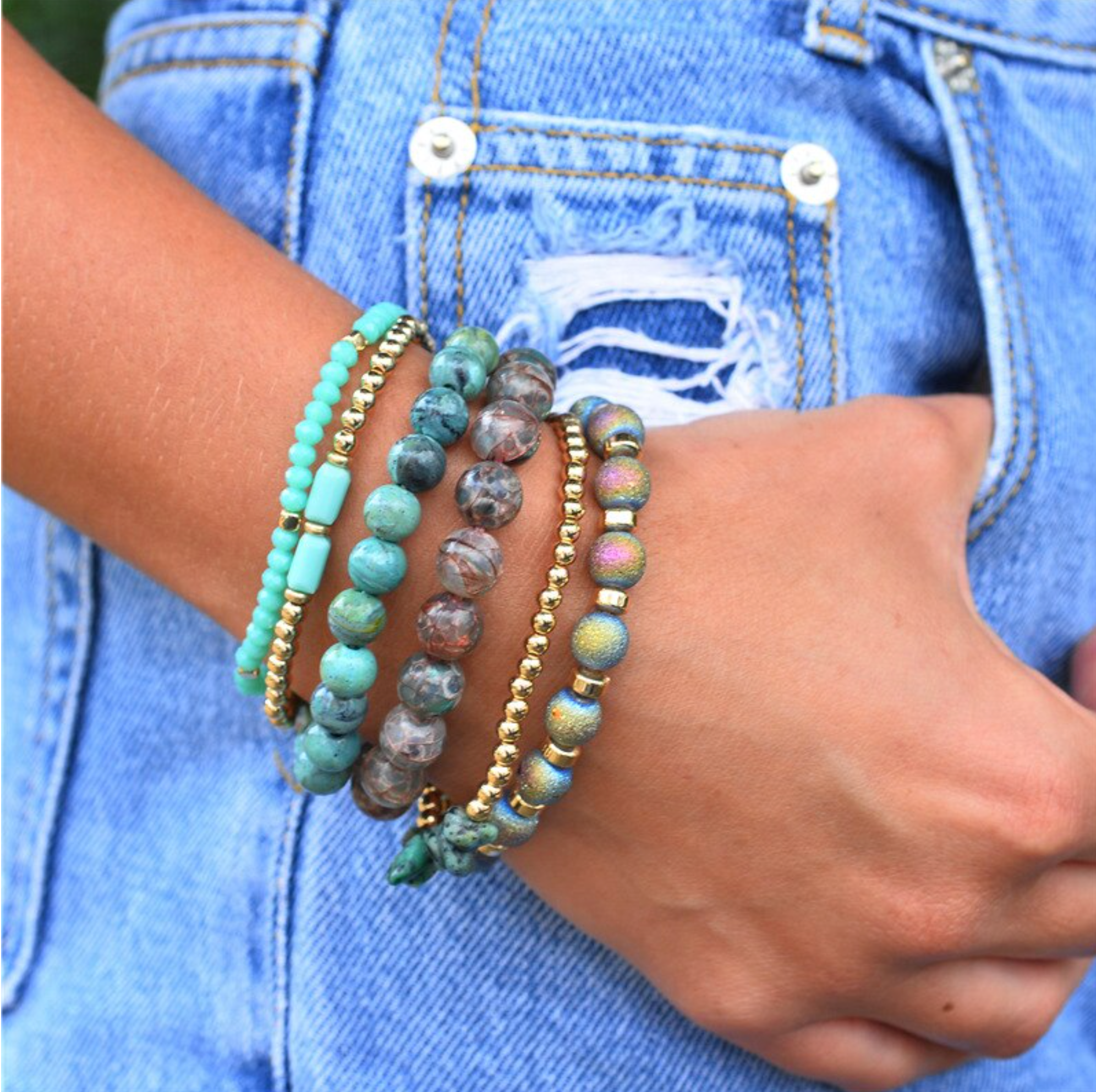 Green and gray beaded bracelet set worn with a denim jacket